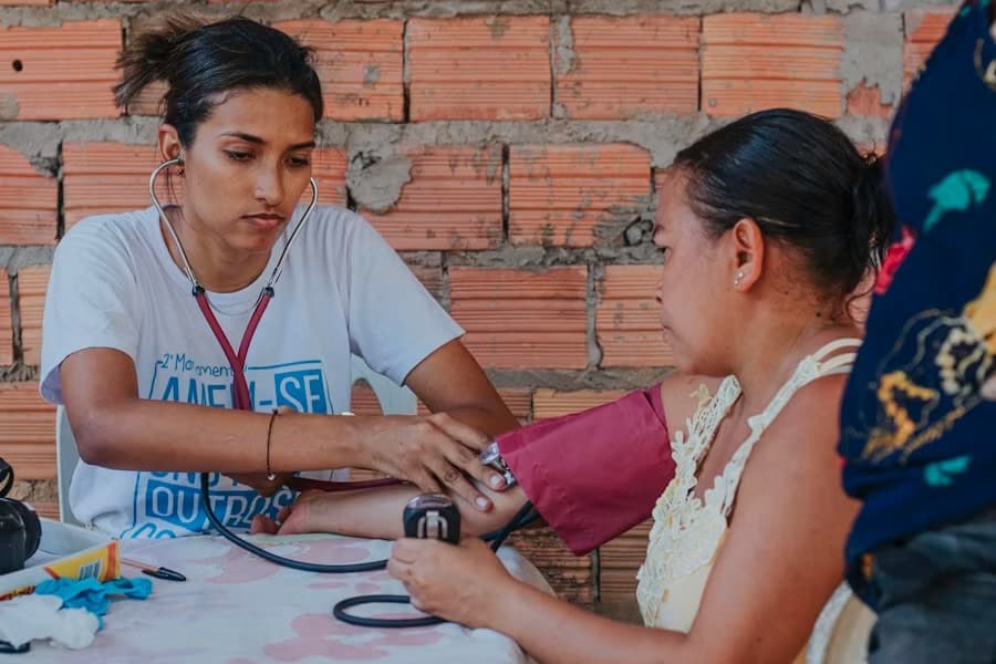 Health worker checking a woman's blood pressure