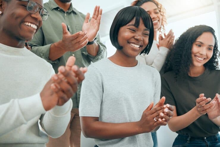 Smiling team members applauding together